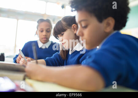 Schoolboys and schoolgirls learning in classroom Stock Photo