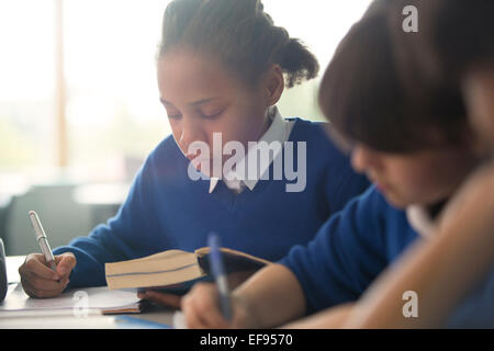 Primary school children writing in classroom Stock Photo