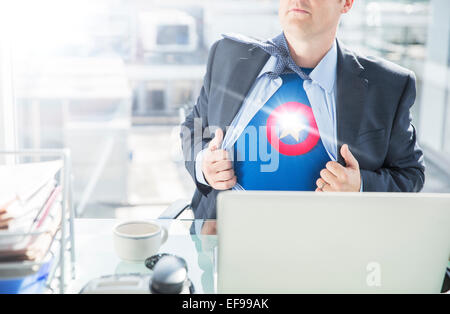 Businessman opening shirt to reveal superhero costume Stock Photo