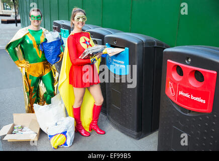 Superhero couple recycling on city sidewalk Stock Photo