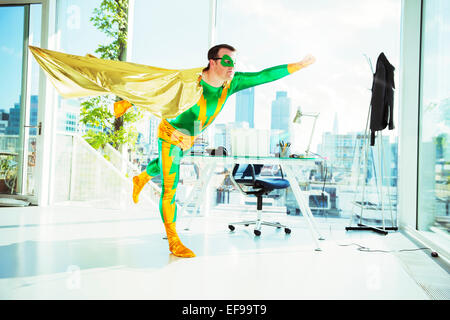 Superhero flying in office Stock Photo