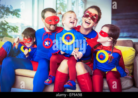Superhero family laughing on sofa