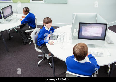 Primary school children working with computers Stock Photo