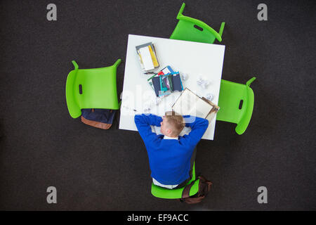 Overhead view of student sleeping on desk Stock Photo