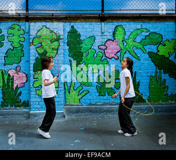 2 girls skipping in gratified school playground in Paddington,London Stock Photo