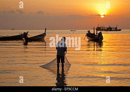 Thai fishing boats silhouetted against sunset, island Ko Tao / Koh Tao, part of the Chumphon Archipelago in Southern Thailand Stock Photo