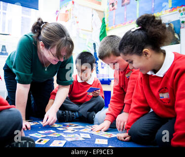Teacher playing snap with children at primary school in London,UK Stock Photo