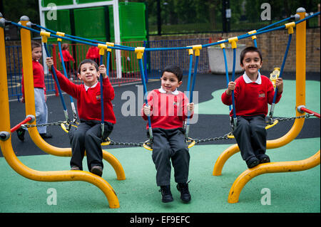 Happy smiling children playing in the playground of Primary school in London W2 Stock Photo