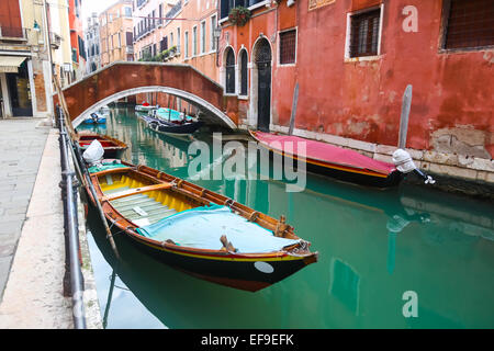 A view of empty boats parked next to buildings and in a water canal in Venice, Italy. Stock Photo