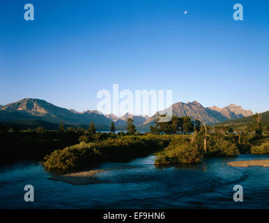 Moon over St. Mary River and mountains,Glacier National Park, Montana, USA Stock Photo