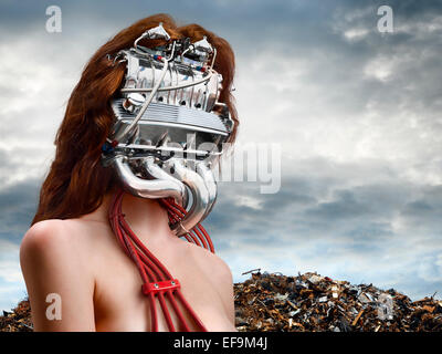 Horizontal fantasy image of woman with a car engine for a head with a junkyard behind her Stock Photo