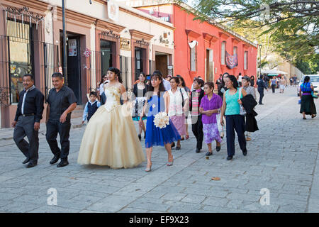 Oaxaca, Mexico - A quinceañera celebration. The girl celebrating her 15th birthday marches with her family in the street. Stock Photo