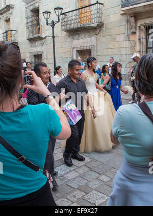 Oaxaca, Mexico - Bystanders cheer and take photographs of a quinceañera celebration on Calle Macedonio Alcalá. Stock Photo