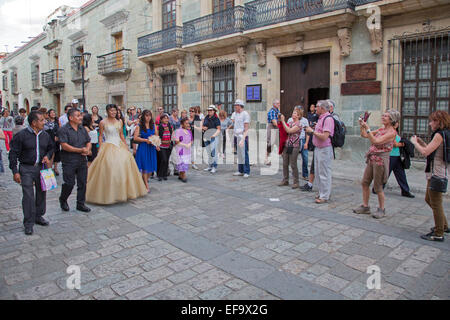 Oaxaca, Mexico - Tourists take photographs of a quinceañera celebration on Calle Macedonio Alcalá. Stock Photo