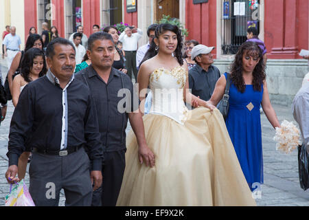 Oaxaca, Mexico - A quinceañera celebration. The girl celebrating her 15th birthday marches with her family in the street. Stock Photo