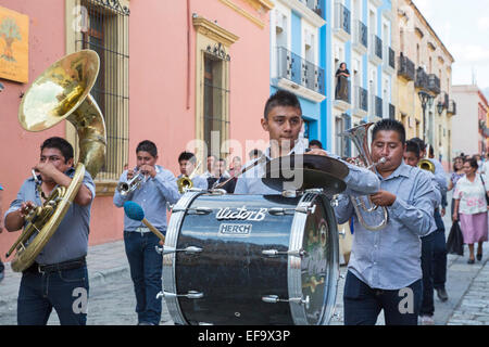 Oaxaca, Mexico - A quinceañera celebration. A brass band followed by a girl celebrating her 15th birthday marches in the street. Stock Photo