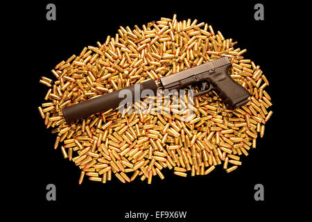 9mm Glock pistol with silencer resting on pile of live ammunition Stock Photo