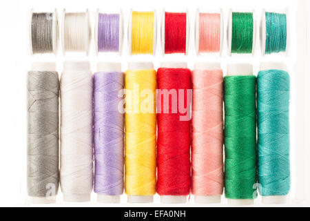 Colorful bobbins and spools of threads isolated on white Stock Photo