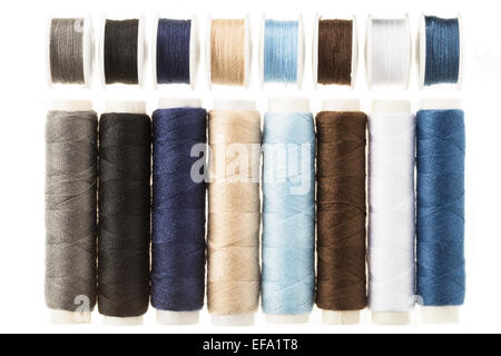 Colorful bobbins and spools of threads isolated on white Stock Photo