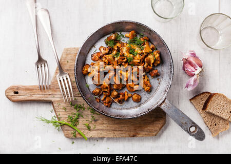 Roasted wild mushrooms in pan on white textured background Stock Photo