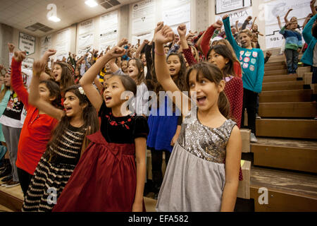 Multiracial middle school girls gesture as they sing carols in a Christmas concert at a high school gymnasium in Aliso Viejo, CA. Stock Photo