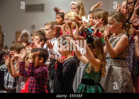 Multiracial young children gesture as they sing carols during Christmas mass at St. Timothy's Catholic Church, Laguna Niguel, CA. Stock Photo