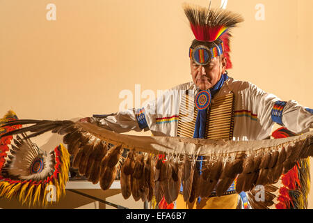 A Navajo Indian dancer wearing full tribal costume spreads his feathers before performing the traditional Eagle Dance during an evening of Native American culture at the Laguna Niguel, CA, public library. Stock Photo