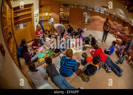 Multiracial young children known as Tiny Tims draw portraits of Jesus Christ in the chapel of St. Timothy's Catholic Church, Laguna Niguel, CA. Note teacher. Stock Photo