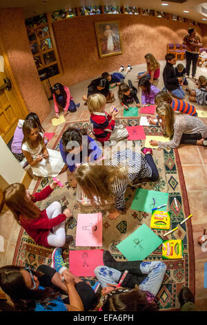 Multiracial young children known as Tiny Tims draw portraits of Jesus Christ in the chapel of St. Timothy's Catholic Church, Laguna Niguel, CA. Note teacher. Stock Photo