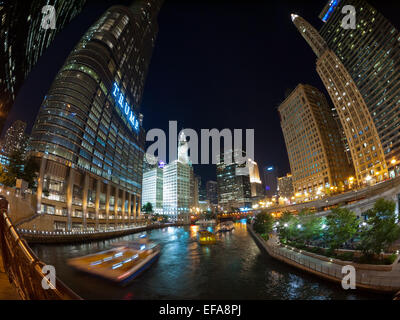 A night, fisheye view of the Chicago River, river boats and towering skyscrapers, as seen from the Wabash Avenue Bridge. Stock Photo