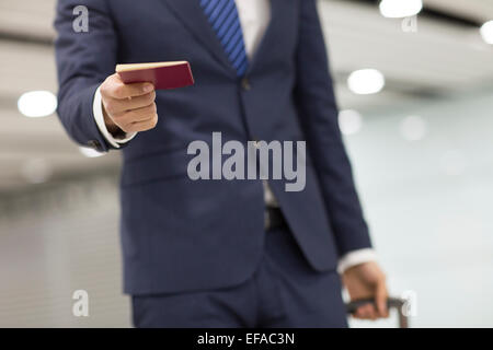 Young businessman showing his passport in airport Stock Photo