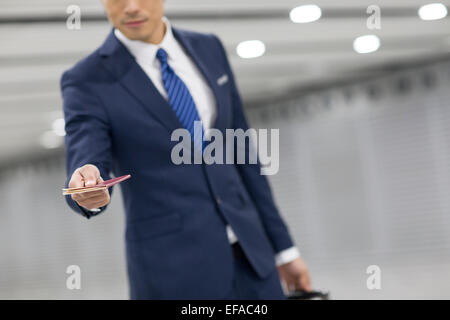 Young businessman showing his passport in airport Stock Photo