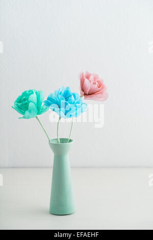 Three flowers made of crepe paper in a vase Stock Photo