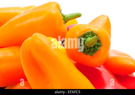 closeup of some sweet peppers of different colors, orange, red and yellow, on a white background Stock Photo
