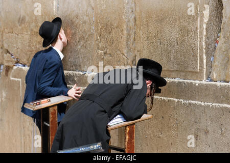Two jewish men are praying in front of the western wall in the old city of Jerusalem Stock Photo