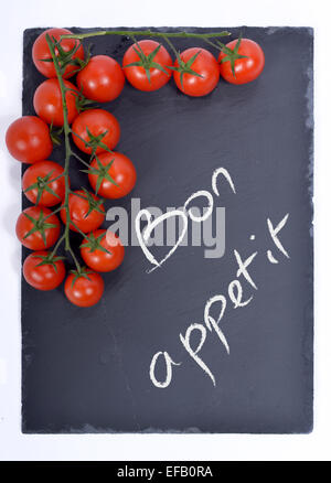 bon appetit written on a blackboard with tomatoes Stock Photo