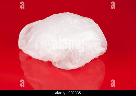 Crumpled white plastic bag on a red background Stock Photo
