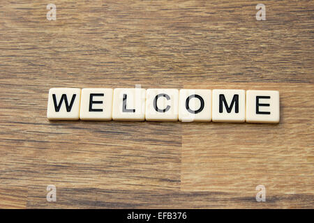 The word welcome written in tiles on a wooden surface Stock Photo