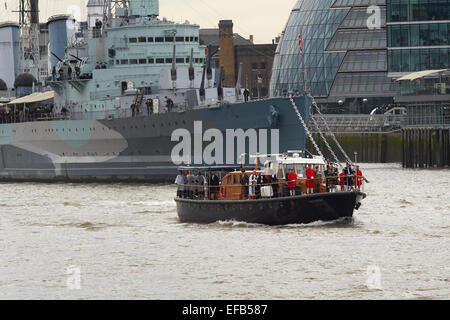 London, UK. 30th January, 2015. The Havengore, the boat which carried the coffin of Winston Churchill 50 years ago today, started the anniversary event by making it's way along the River Thames from Tower Bridge to Westminster. On its journey passing HMS Belfast, the WW2 battleship which is moored on the Thames. Credit:  Steve Hickey/Alamy Live News Stock Photo