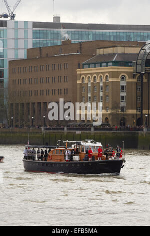 London, UK. 30th January, 2015. The Havengore, the boat which carried the coffin of Winston Churchill 50 years ago today, started the anniversary event by making it's way along the River Thames from Tower Bridge to Westminster. On its journey passing HMS Belfast, the WW2 battleship which is moored on the Thames. Credit:  Steve Hickey/Alamy Live News Stock Photo