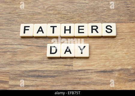 The word fathers day written in tiles on a wooden surface Stock Photo