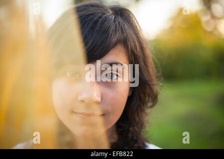 Young cute girl portrait half face hidden behind a veil. Stock Photo