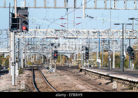 Red signals and complex overhead power line arrangement at Nuneaton railway station Stock Photo