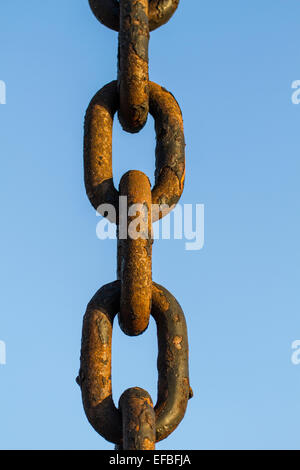 thick rusty chain on a blue sky background Stock Photo