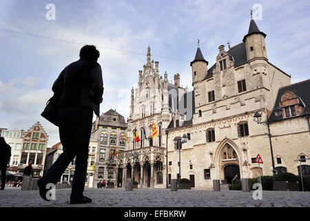 MECHELEN, BELGIUM - OCTOBER 2014: Silhouette walks on the Grote Markt in front of the town hall Stock Photo