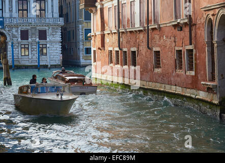 Two water taxis passing on a canal Venice Veneto Italy Europe Stock Photo