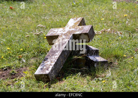 Broken gravestone cross laying in grass at Bedford cemetery, Bedford, Bedfordshire, England Stock Photo