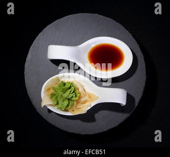 Wasabi and soy sauce as yin and yang symbol on black Stock Photo