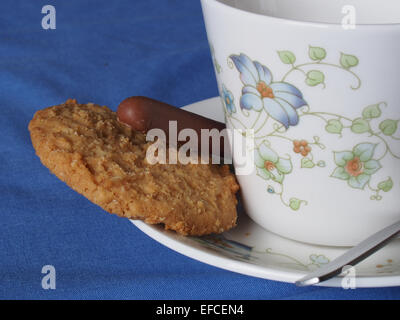 chocolate finger and oat biscuit with a teacup and saucer Stock Photo