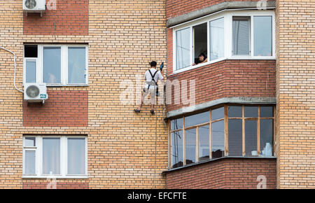 Mounting the air conditioner on the wall of an apartment house Stock Photo